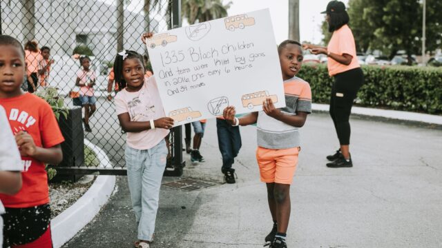 Young children hold sign protesting gun violence